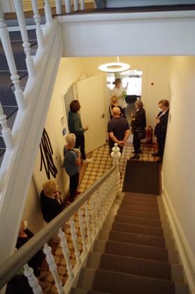 Treppenhaus. Frau Roters erläutert die Denkmalsubstanz: Alte seltene Zementfließen und das bauzeitliche  Treppenhaus